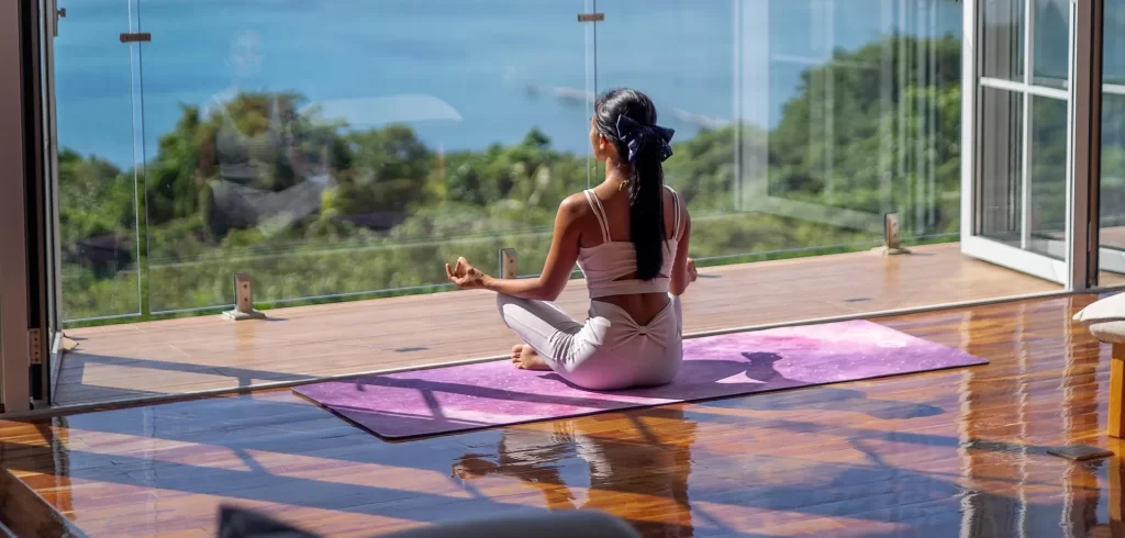 Een rustig yogamoment met uitzicht op zee als symbool voor ontspanning, beweging en innerlijke balans.